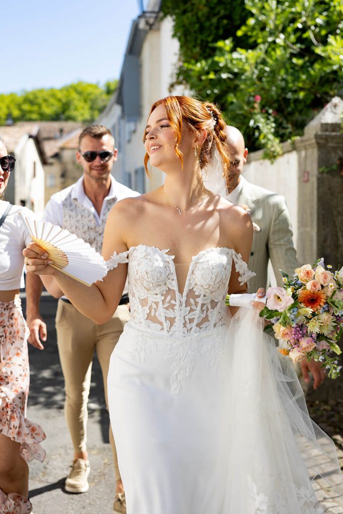 La mariée utilise son éventail pendant le cocktail de son mariage. Une photo capturée par Meyline Esparcieux, photographe reportage mariage Dax, Landes.