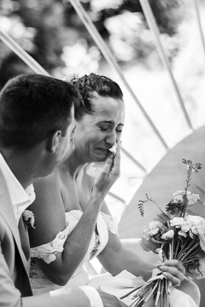 Pendant la cérémonie de mariage laïque, la mariée pleure d'émotion. Un moment intense capturé par Meyline Esparcieux, photographe reportage mariage Dax, Landes.