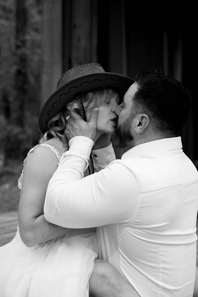 Un couple de mariés s'embrasse. La mariée porte un chapeau. un mariage ambiance folk photographié par Meyline Esparcieux, photographe mariage Dax Landes.